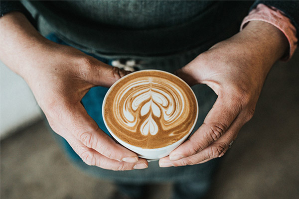 オーナーがコーヒーを持っているところ